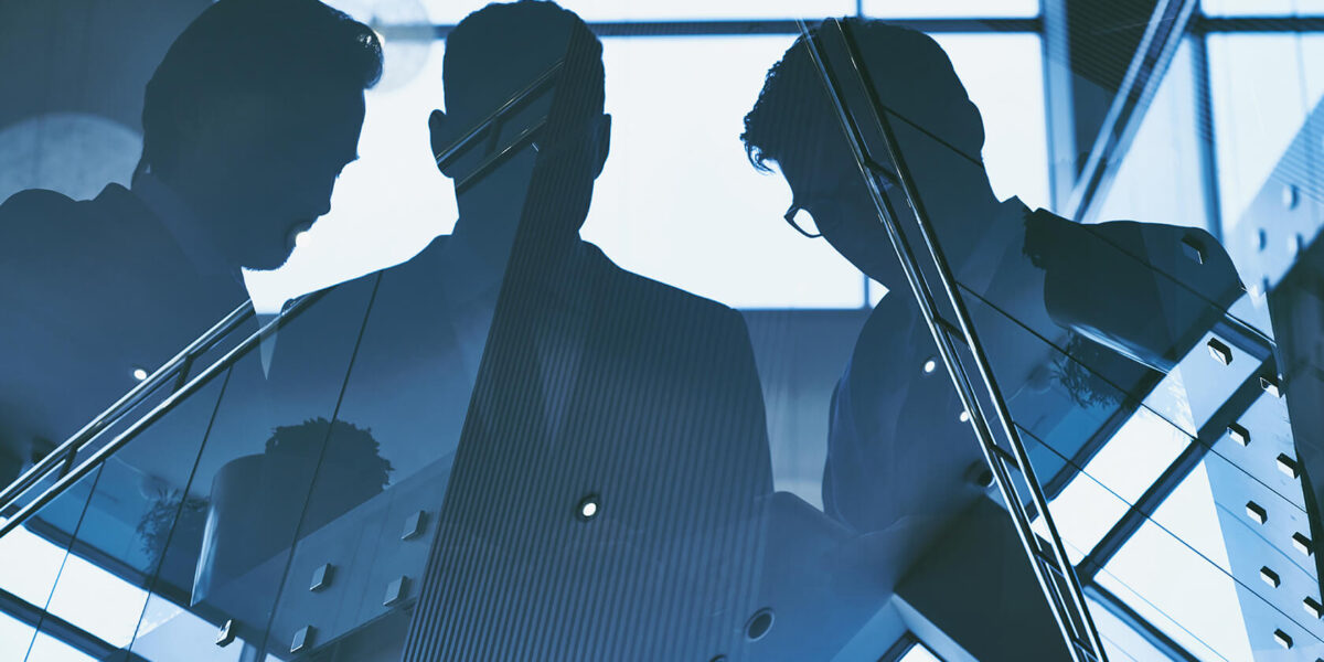 Reflection of three men on building
