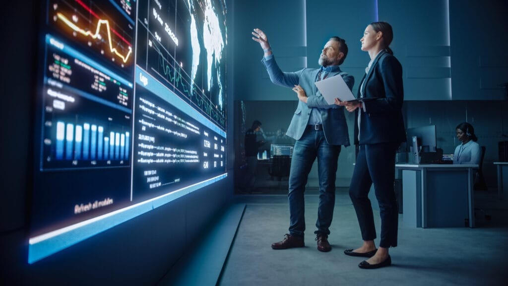 IT Professionals reviewing data on large screen
