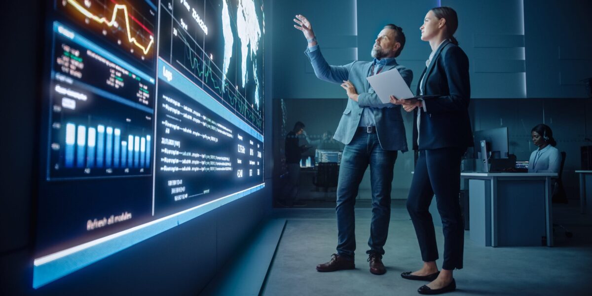 IT Professionals reviewing data on large screen