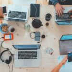 Many laptops, ipads and cell phone on a conference room
