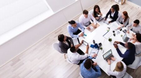 M365 Intune Entra ID Group of people in conference room working on mobile devices