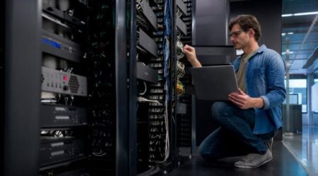 IT engineer kneeling and working on IT network server equipment