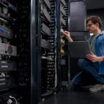 IT support technician fixing a network server at an office IT engineer working on network and server equipment