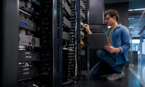IT support technician fixing a network server at an office IT engineer working on network and server equipment