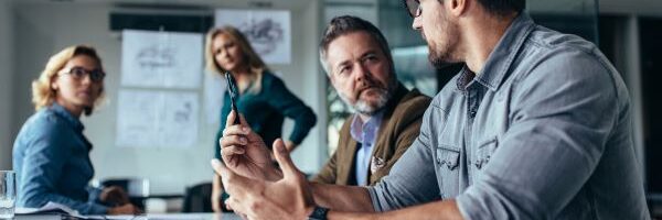 Group of four people in a conference room discussing IT strategy